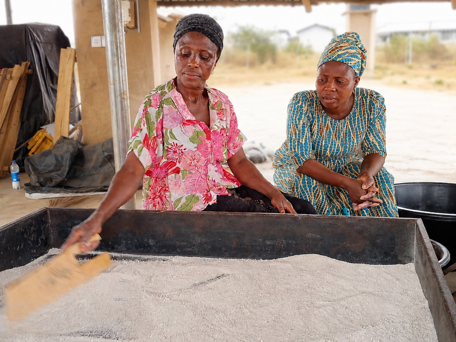 Community members working at an outdoor bioenergy processing site